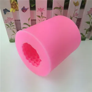 Roze cilindrische siliconen mal voor het maken van kaarsen en zeep met dennenappeltextuur.