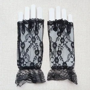 Detailed close-up of black lace fingerless gloves showing delicate floral pattern and ruffle trim.