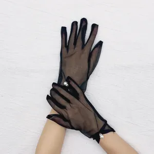 Detail shot of black sheer mesh lace gloves with delicate pearl charms for sun protection.
