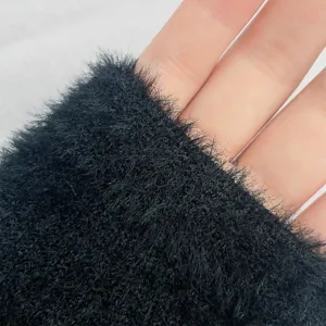 Black fuzzy knit glove fabric detail texture close up warm winter accessory soft comfortable