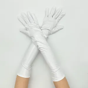 Vue détail des gants longs en cuir verni de performance, accessoire de costume ajusté.