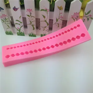 Vista dettagliata dello stampo in silicone rosa con bordo di perle per torte e dolci.