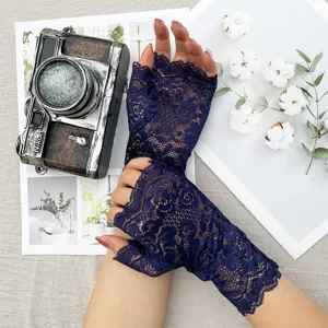 Detailed shot of dark blue lace fingerless gloves, showing delicate floral pattern and texture.