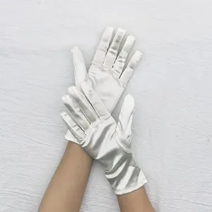 Close up detail of elegant white satin gloves showcasing smooth shiny fabric and stretch fit.