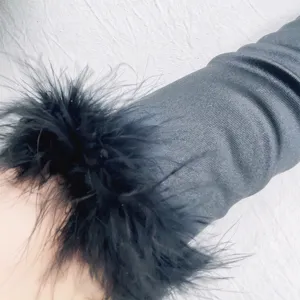 Close-up detail of the vintage black feather trimmed satin long glove worn on arm.