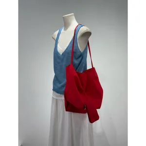 Dettaglio borsa a spalla morbida rossa, capiente shopper casual per uso quotidiano.