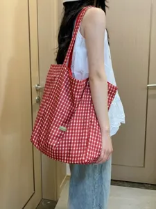 Red and white plaid canvas tote bag detail view, casual everyday commuter shoulder bag style.