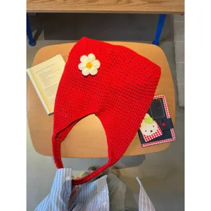 Detailed view of red crochet hobo shoulder bag featuring handmade white flower accent.