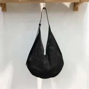 Black hollow woven shoulder bag detail view, casual minimalist design for daily summer vacation.