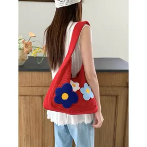 Detail view of the red knitted shoulder bag featuring cute 3D plush flower decorations and strap.