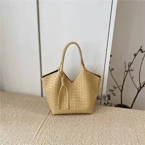 Beige woven leather handbag detail, elegant intrecciato style tote bag for women.