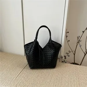 Exquisite black woven leather tote bag detail showcasing elegant craftsmanship and texture.