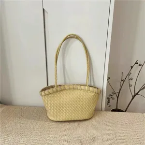 Detail view of the elegant light yellow woven leather shoulder bag with spacious interior design.
