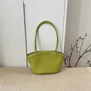 Detailed shot of woven leather tote handbag featuring classic intrecciato design and handles.
