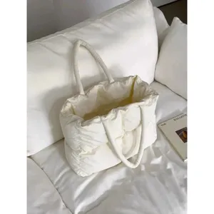 White quilted puffer tote bag detail shot, soft down cotton fabric, minimalist lifestyle prop.