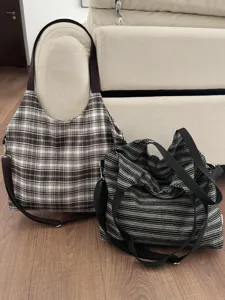 Detail view of casual canvas shoulder bags featuring classic check and stripe patterns.