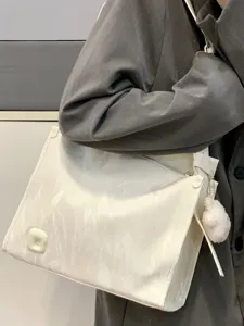 Detail view of large white shoulder tote bag with furry charm, casual daily commuting use.