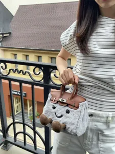 Cute cartoon smiling plush crossbody bag for women, cozy winter fluffy handbag with handle.