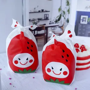 Sachets d'emballage motif fraise mignons pour biscuits et nougat avec attaches métalliques.