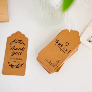 Close up detail view of vintage brown kraft paper thank you tags with decorative leaf prints.