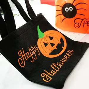 Close-up detail shot of black Halloween felt candy bag featuring pumpkin print.