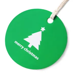 Round green Christmas gift tag with white tree design, perfect for holiday hanging decor.