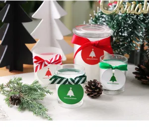 Christmas scented candle set in glass jars with festive ribbons and tree tags for decor.
