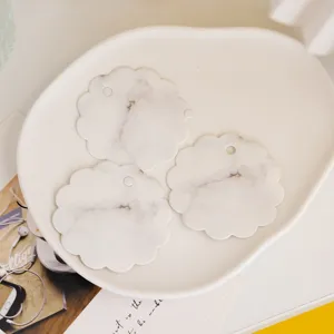 Close-up of marble pattern scalloped message cards and decorative hang tags on white tray.