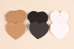 Close-up detail of heart shaped scalloped paper gift tags in kraft, black and white colors.