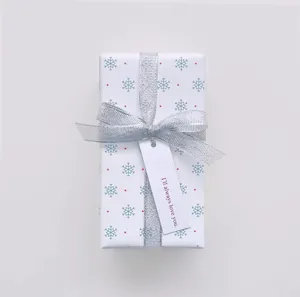 Détail de ruban métallique argenté sur boîte cadeau, idéal pour emballage de fête.