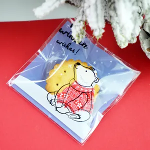 Sachet d'emballage de biscuits de Noël autocollant avec un joli motif d'ours et fond festif.