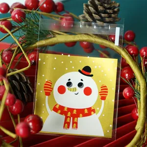 Christmas clear self-adhesive cookie candy bags featuring cute gold snowman design detail