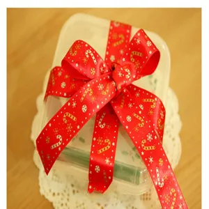 Weihnachtliches rotes Band mit goldenen Zuckerstangen-Print für Geschenkschachtel-Details.