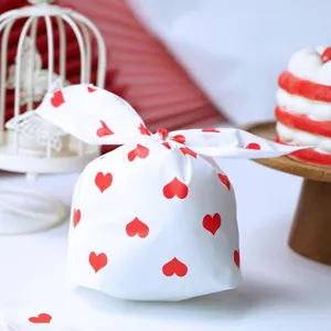 Détail en gros plan du sac d'emballage cadeau blanc en oreilles de lapin avec cœur rouge.