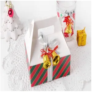 Detail shot of festive Christmas gift box decorated with silver ribbon and gold jingle bells.