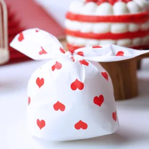 Sachet blanc avec cœurs rouges, design oreilles de lapin, idéal pour biscuits de saint-valentin.