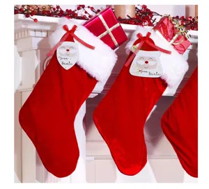 Red velvet Christmas stockings with white faux fur trim, gift boxes and cute Santa tags.