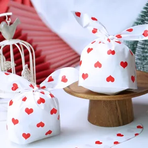 Détail des sacs à bonbons oreilles de lapin à cœurs rouges pour cadeaux festifs.