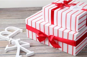 Boîtes cadeaux à rayures rouges et blanches avec rubans de satin rouge pour emballage.