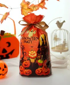 Λεπτομέρεια τσάντας δώρου καραμέλας Halloween με τύπωμα κολοκύθας και καφέ φιόγκο.
