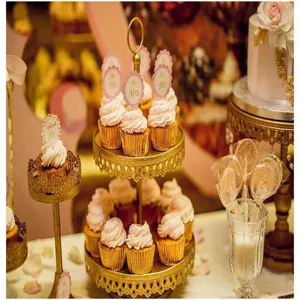 Vista detallada de elegantes soportes dorados para cupcakes y deliciosos muffins en mesa.