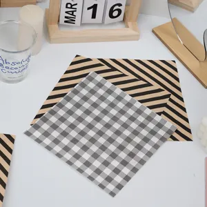 Details of black and white checkered and striped greaseproof baking paper sheets for food wrapping.
