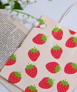 Gros plan détaillé d'un charmant sac cadeau en papier avec un joli motif de fraises rouges.