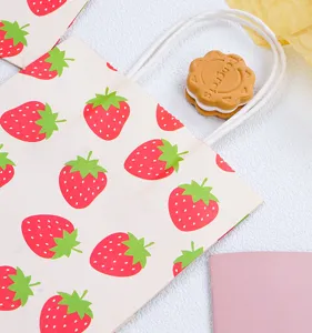 Detail de sac cadeau en papier fraise mignon, materiau en papier de qualite avec poignees.