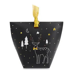 Detailed view of Christmas paper candy box with gold deer design and ribbon closure.