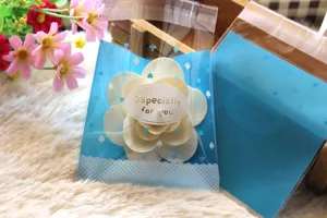 Bolsas de galletas autosellantes azules con flor de madera y texto para empaquetar postres