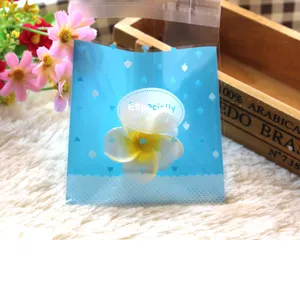 Bolsas de galletas autosellantes azules con diseño de corazones y flores para repostería.