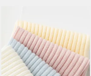 Vista detallada de calcetines cortos acanalados en tonos pastel con suave tejido de punto.
