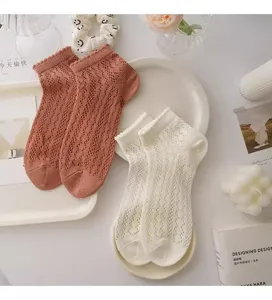 Detailed view of women's breathable mesh lace short socks in white and pink, summer style.
