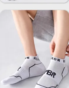 Close-up detail view of breathable mesh short sports socks with knit letters and black lines.